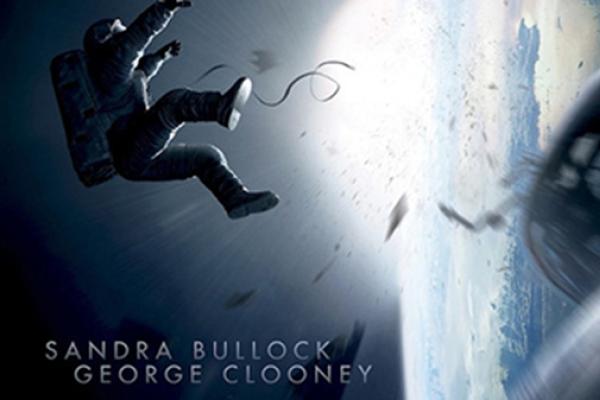 Gravity film poster. Image of astronaut floating in space. Starring George Clooney and Sandra Bullock
