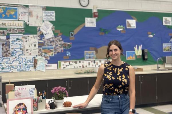 Teacher standing in front of her desk