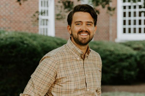 Photo of Zachary Milford smiling at camera, standing in front of Taylor Education Building