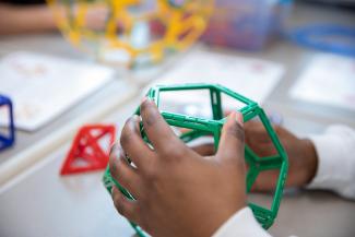 Closeup of hand of student holding STEM shape