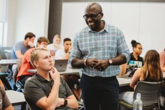 Dr. Agyemang teaching a course and interacting with a student