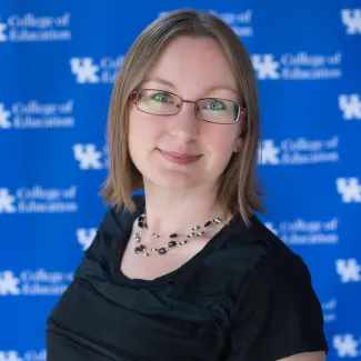 Headshot of Kathleen Aspiranti against blue UK College of Education backdrop