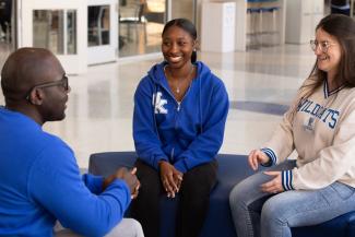 Students smiling and talking with Dr. Agyemang