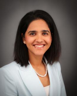 Photo of Dr. Simran K. Sethi smiling and wearing a light blue jacket against a gray background