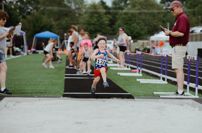 Photo of a child doing the long jump. Photo credit, Asbury University.