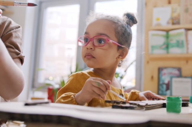 Stock image of a preschool age child sitting at a school desk