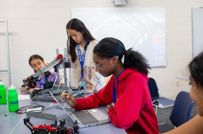 Three students work to build a robot at STEM Camp