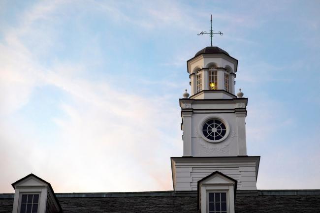 The spire of the Taylor Education Building against a cloudy sky