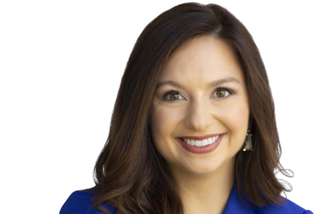 Photo of woman smiling at camera wearing a blue blazer