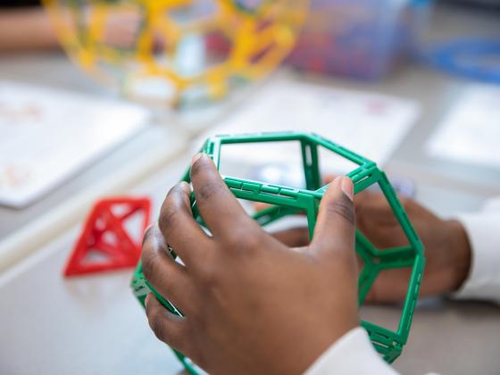 Closeup of hand of student holding STEM shape