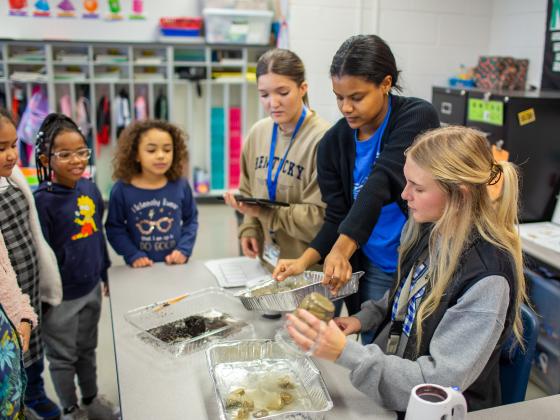 Students working with children in a classroom
